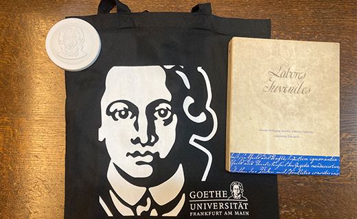 ゲーテをかたどったメダル、ゲーテの子ども時代の勉強ノートの複製版、布製バッグ